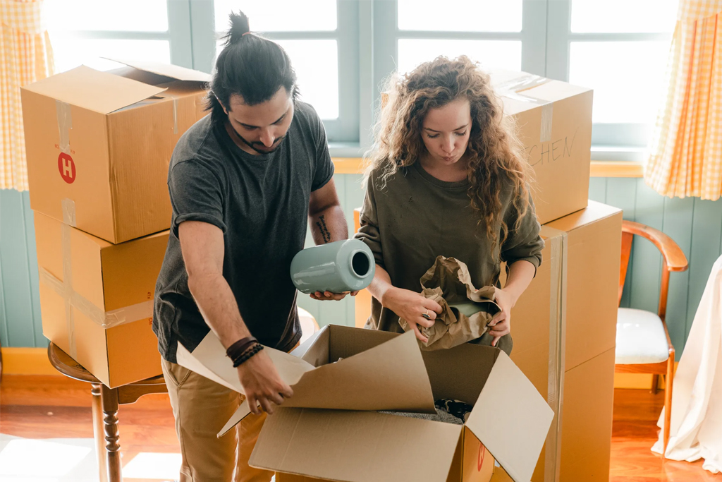 couple packing belongings into moving boxes