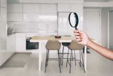 Image of a person holding a magnifying glass in a kitchen