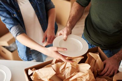Image of packing fragile dishes in a box with paper