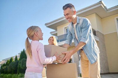 Image of a father handing his daughter a small moving box